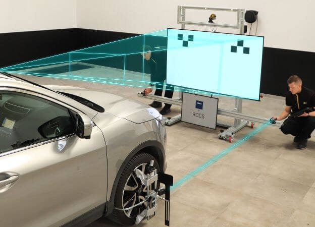 Technicien réalisé un calibrage de caméra ADAS sur un pare-brise