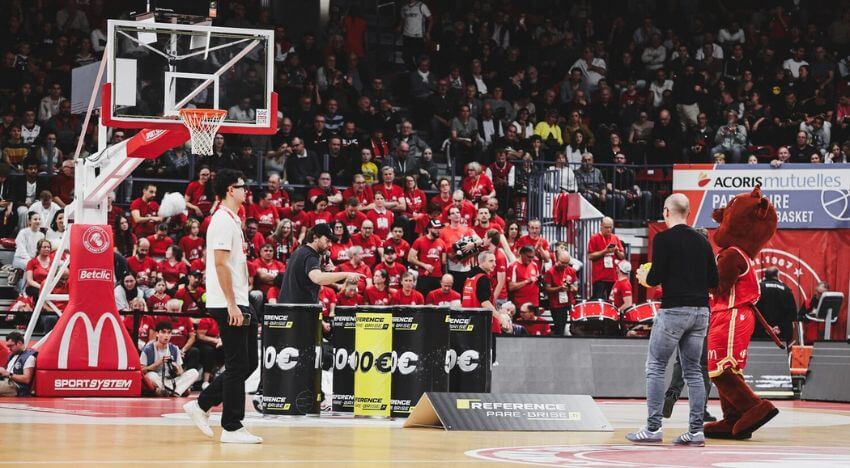 Homme lance ballon basket dans barils