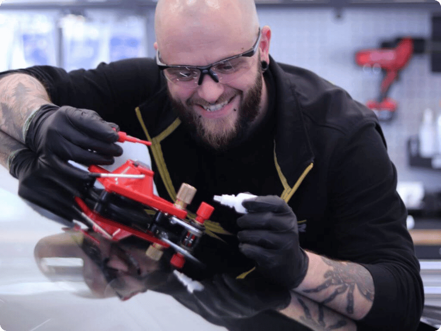 Technicien répare un impact sur un pare-brise