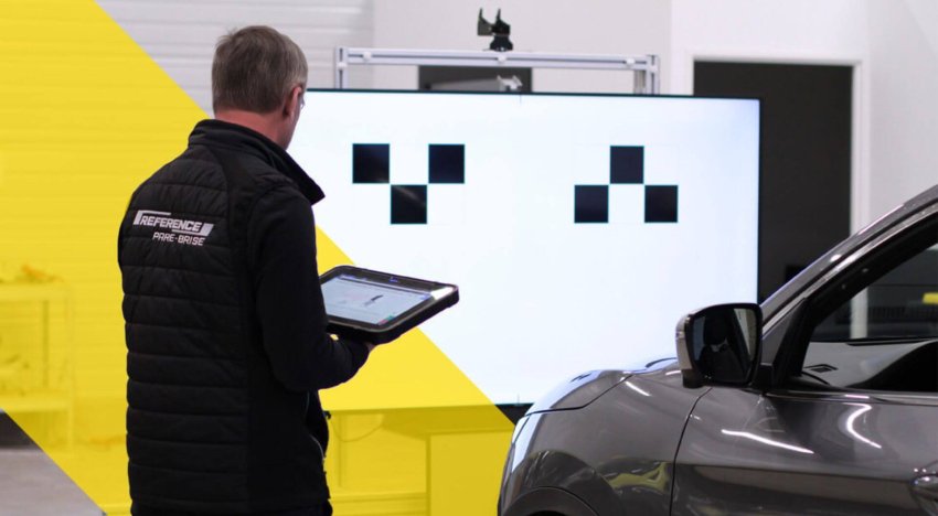 Technicien calibre la caméra ADAS d'un pare-brise