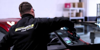 Technicien vitrage pose un pare-brise